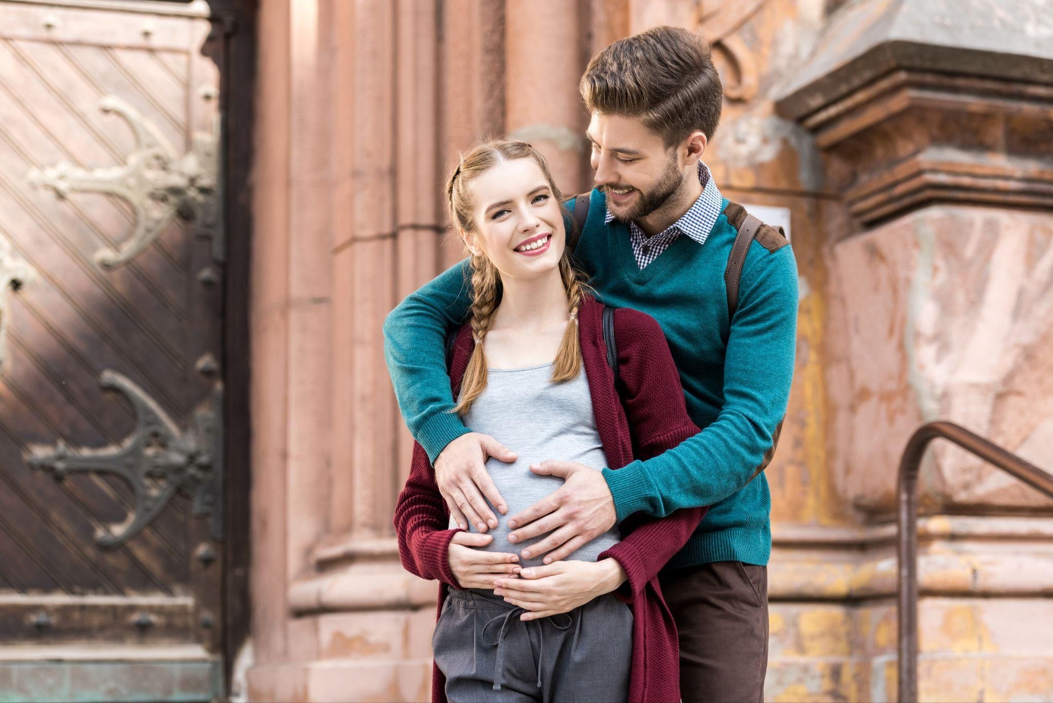 A pregnant couple embracing warmly, showcasing love and support.