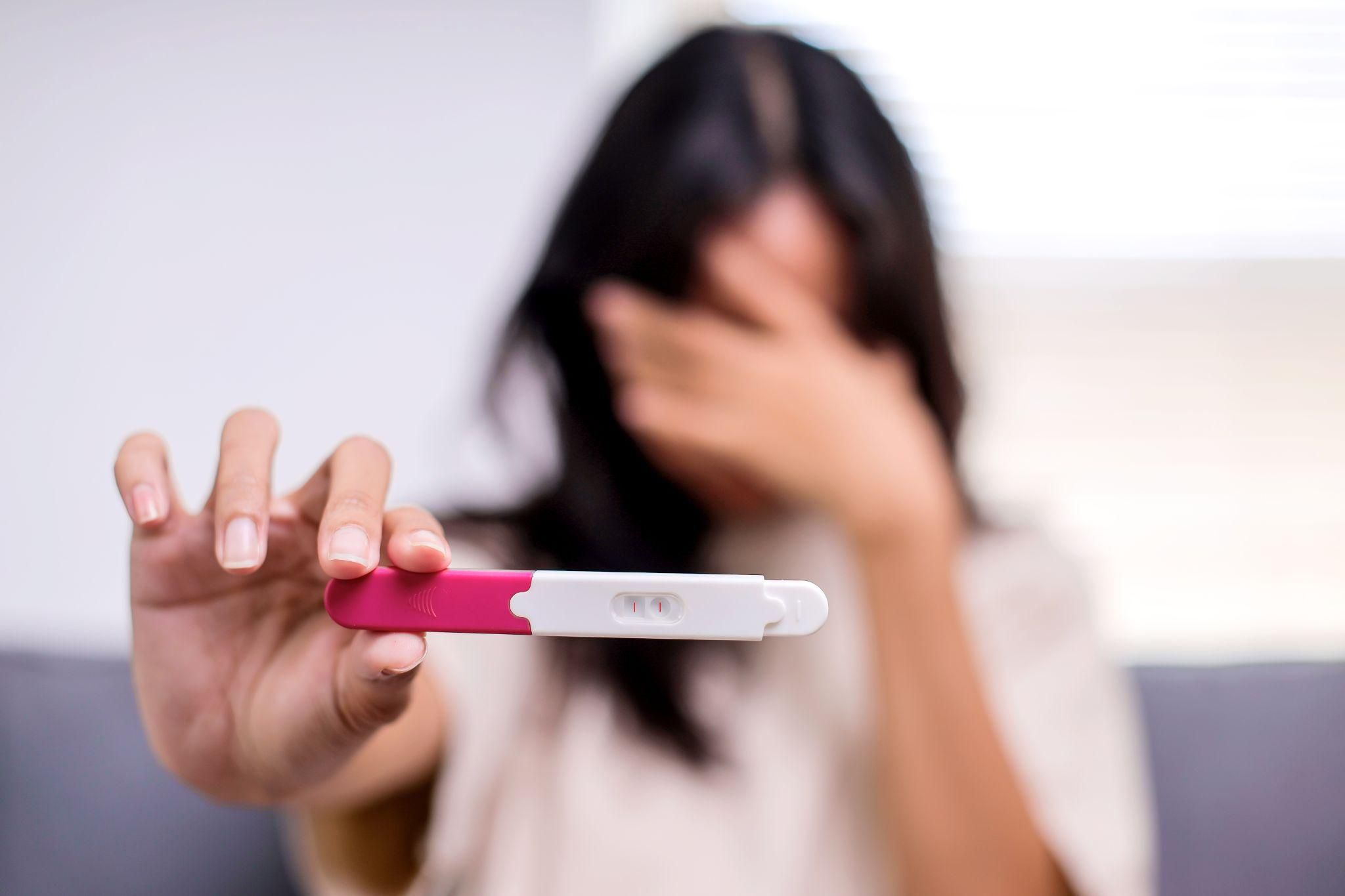 A happy expectant mother recognising early pregnancy symptoms.