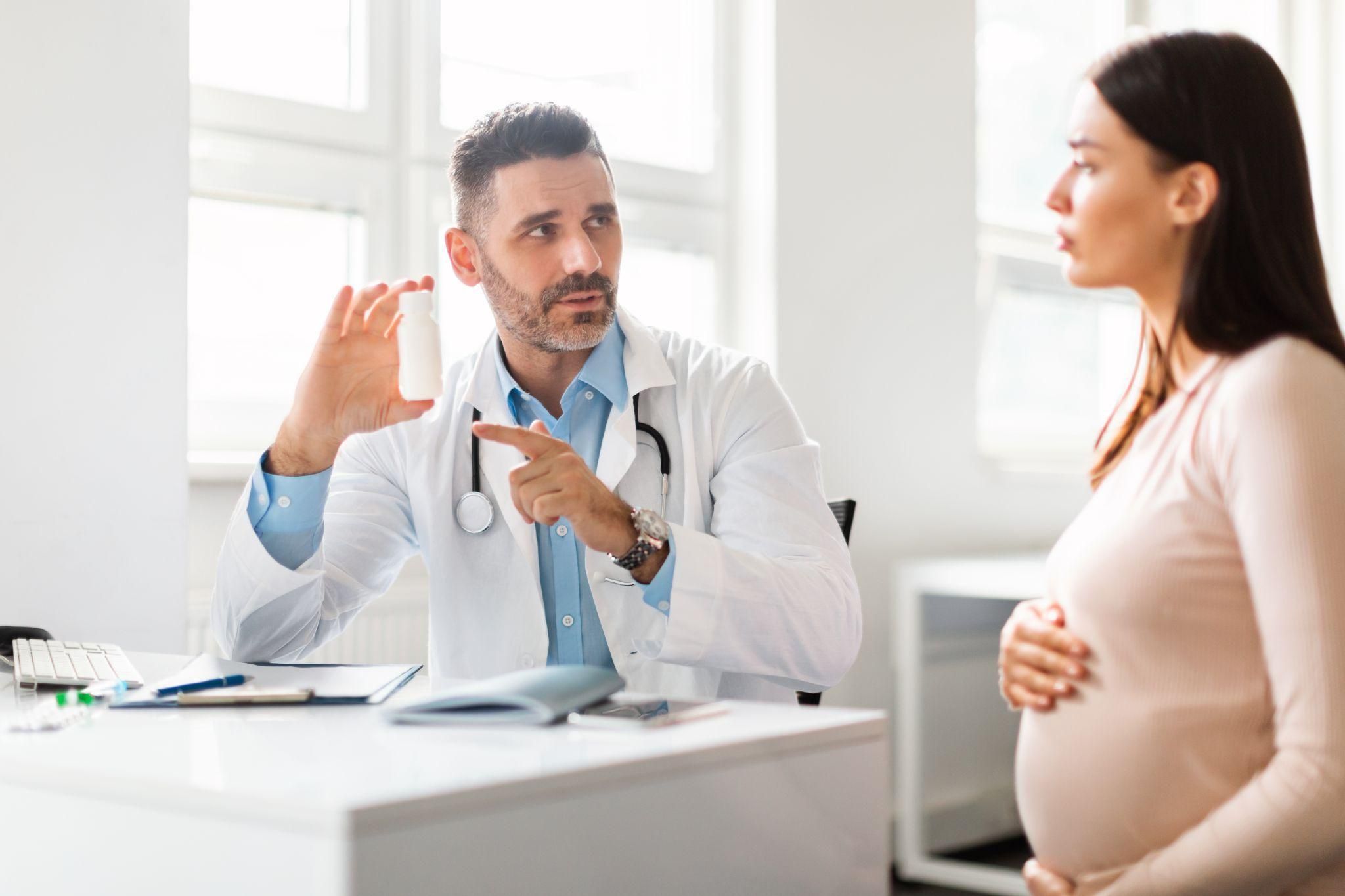 A pregnant woman in an antenatal checkup, discussing APS and pregnancy care with her doctor.