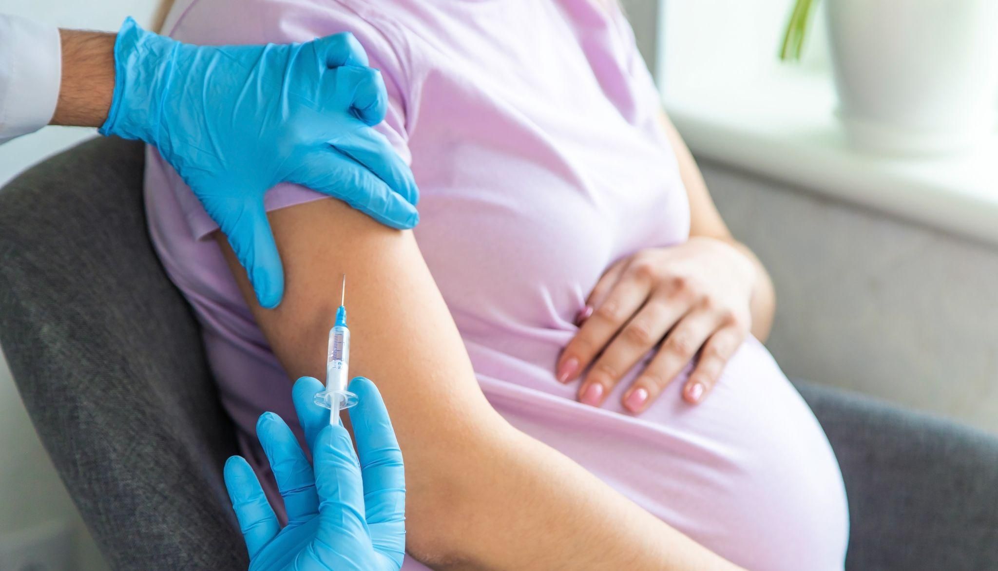 Pregnant woman receiving flu vaccine during antenatal appointment.