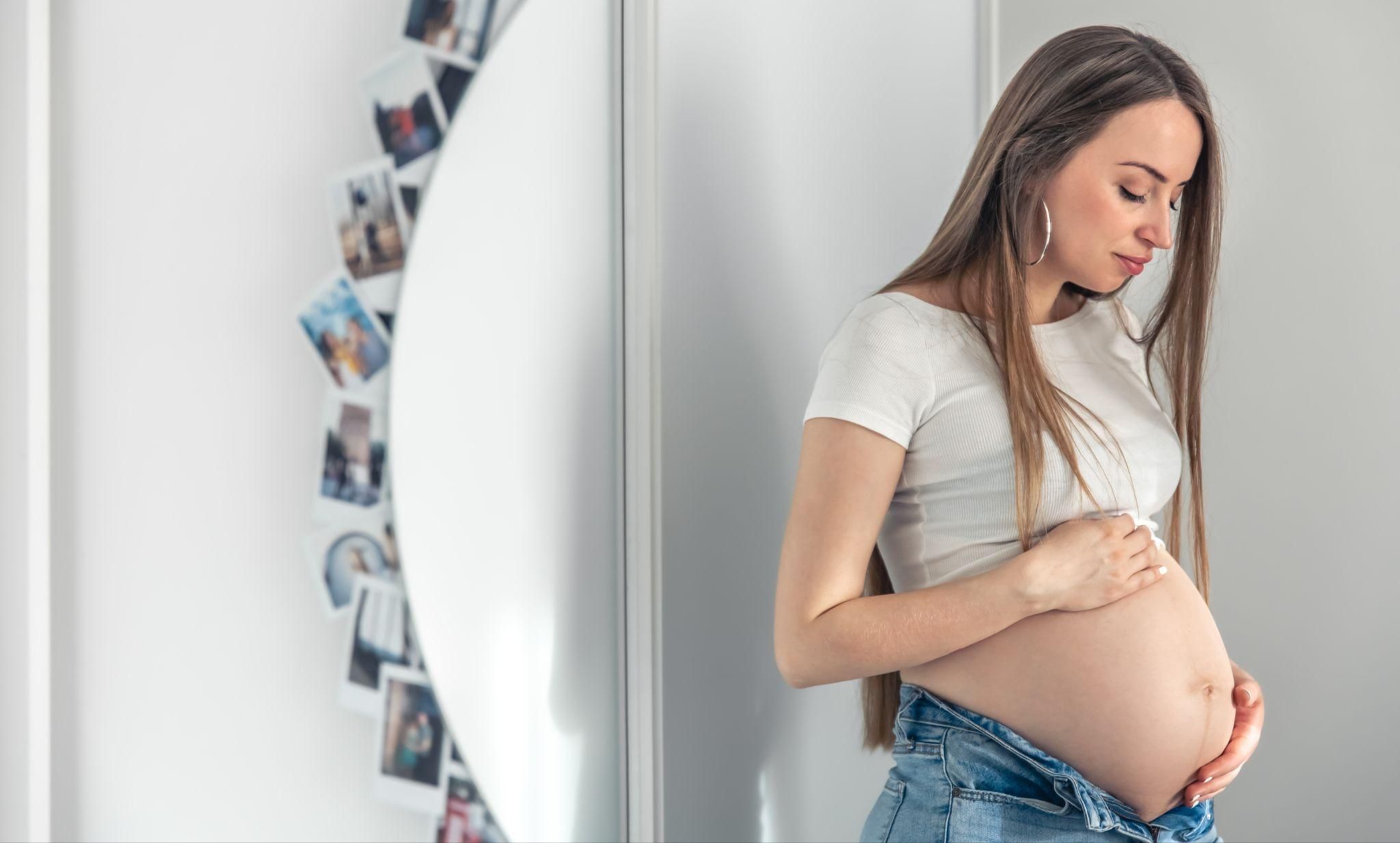 Pregnant woman thinking about the connection between her baby’s movements and sleep patterns.