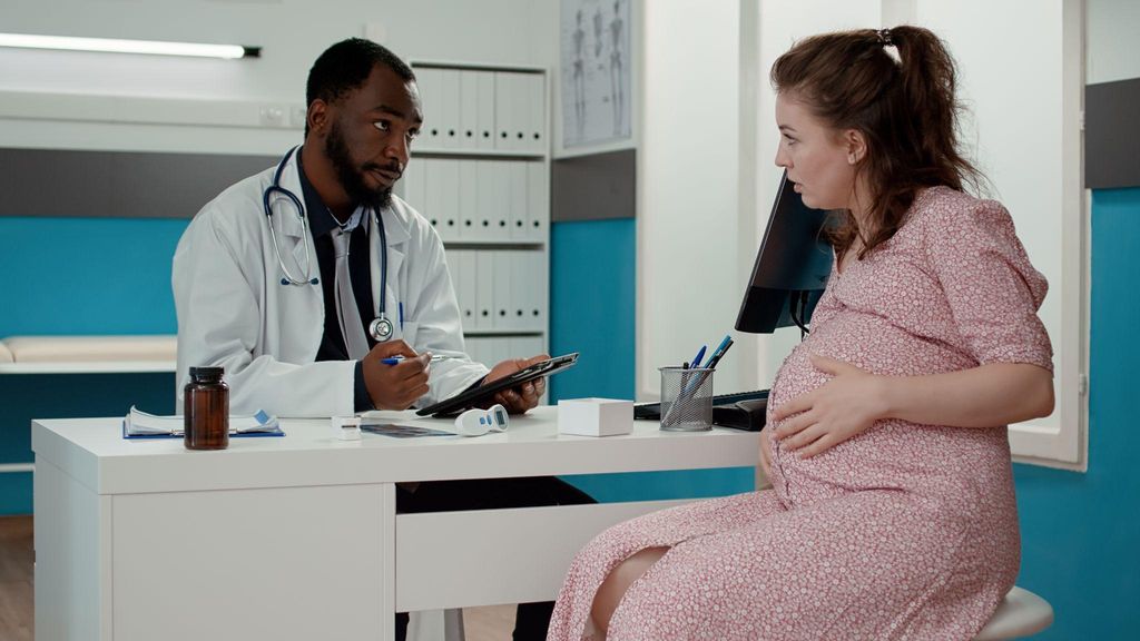 Pregnant woman shares medical history with doctor.