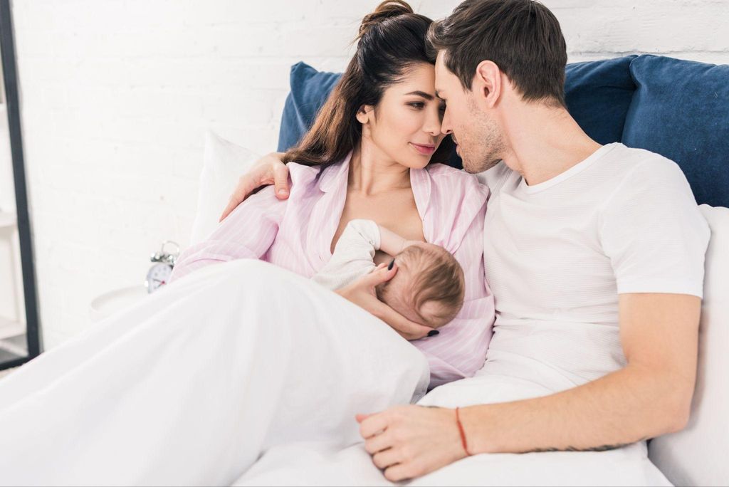 A couple bonding with their newborn in a warm home environment.