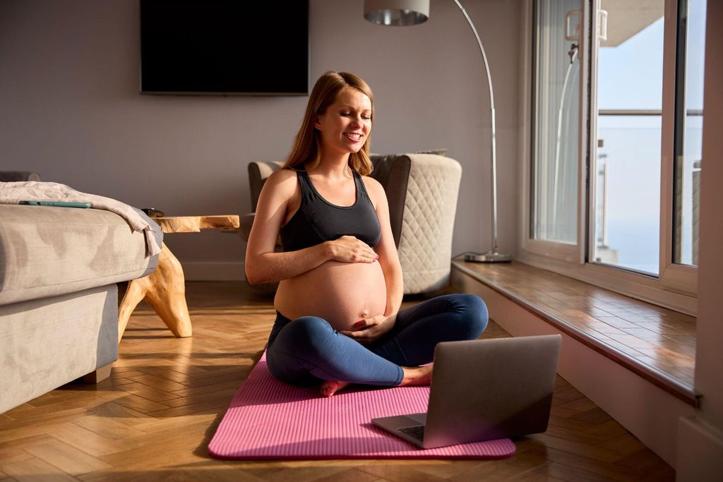 Pregnant woman practising yoga during pregnancy to reduce stress.