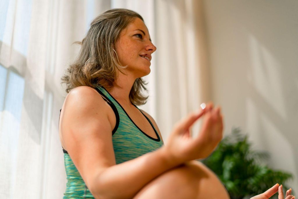 A serene pregnant woman meditating and practising antenatal breathing techniques.