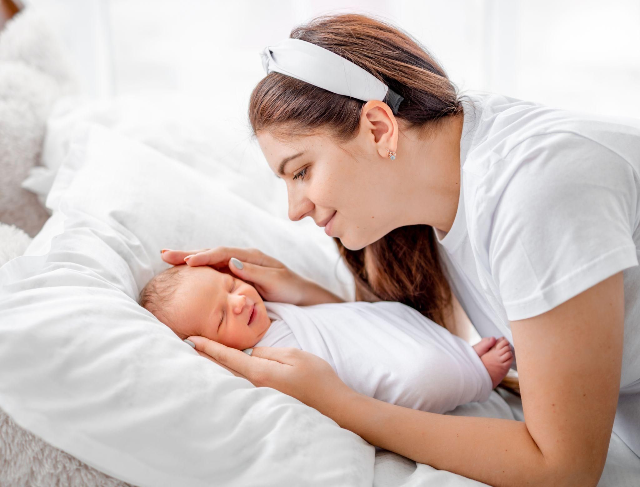 A newborn baby gazing at their parent’s face, engaging in eye contact.