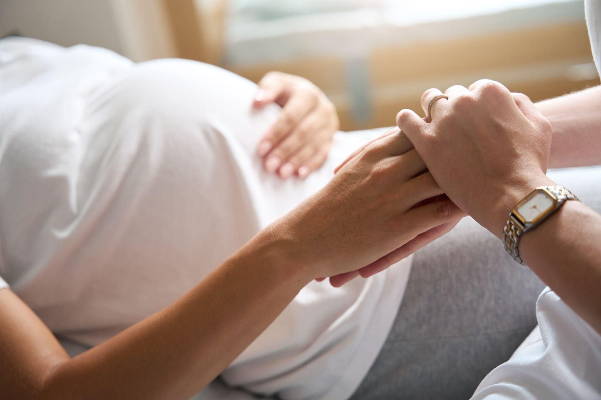 A supportive birth partner encouraging and comforting a woman in labour.