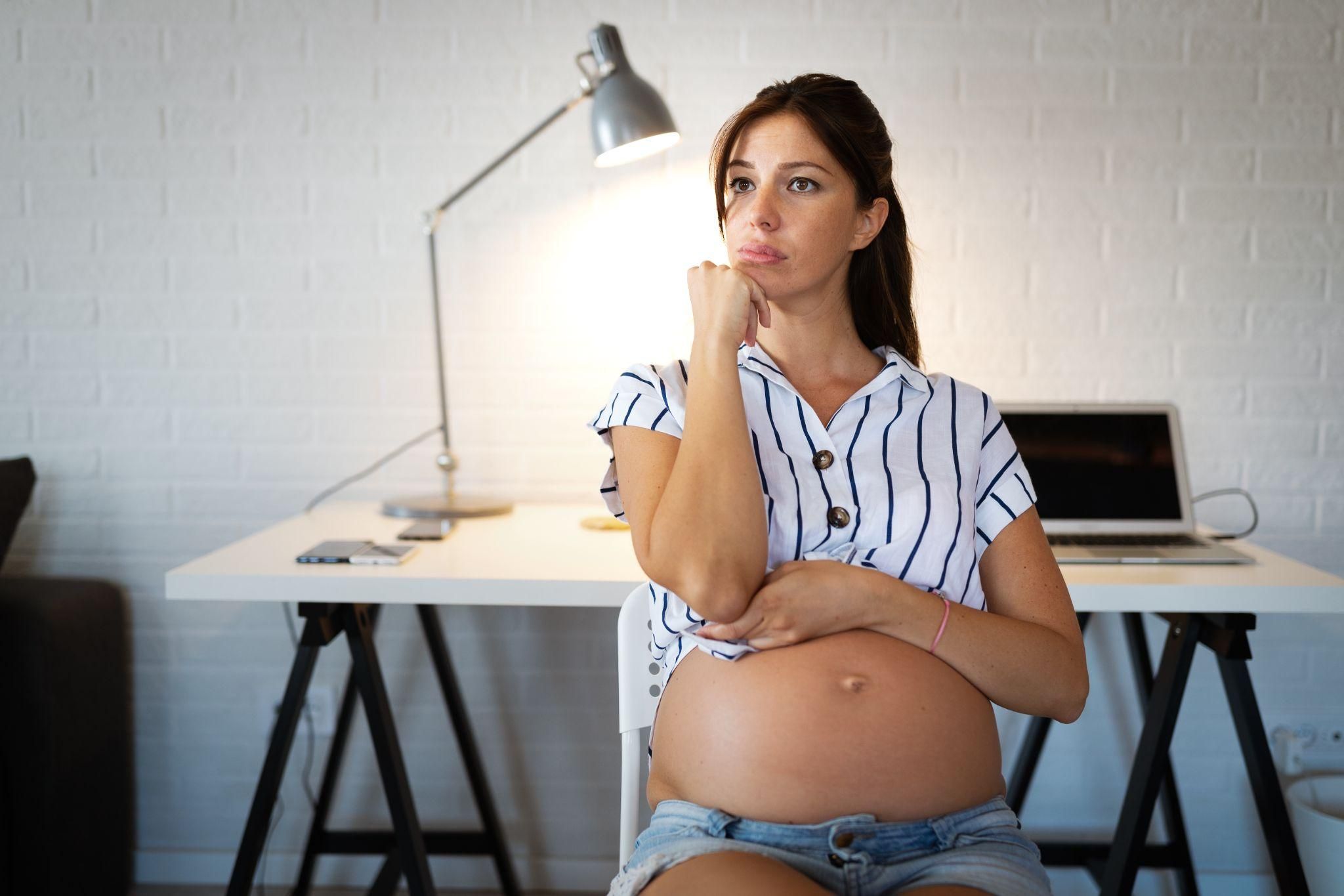 A worried pregnant woman contemplating her future with her husband.