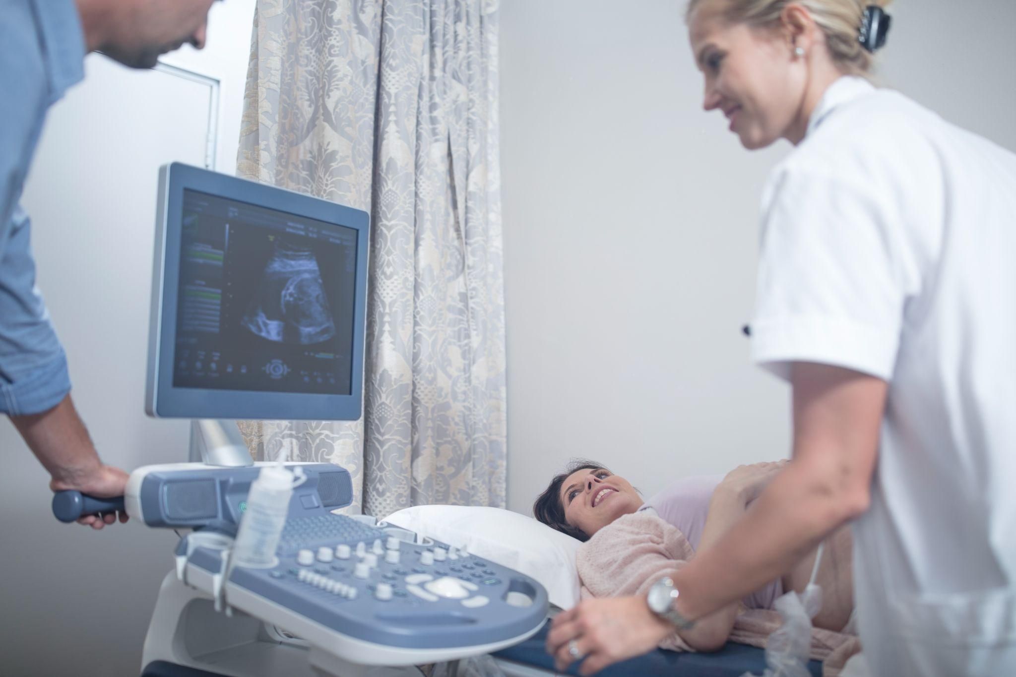 A pregnant woman receiving an ultrasound during an antenatal checkup.