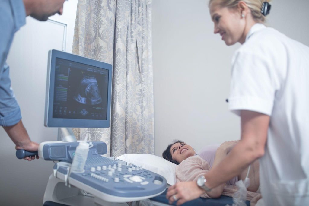 A pregnant woman receiving an ultrasound during an antenatal checkup.