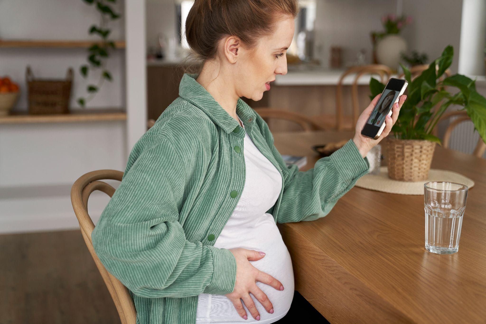 A pregnant woman scrolling social media for antenatal advice.