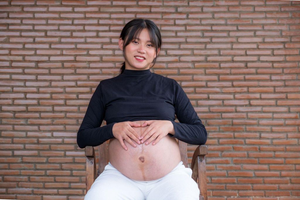 Pregnant woman with a visible linea negra on her abdomen.