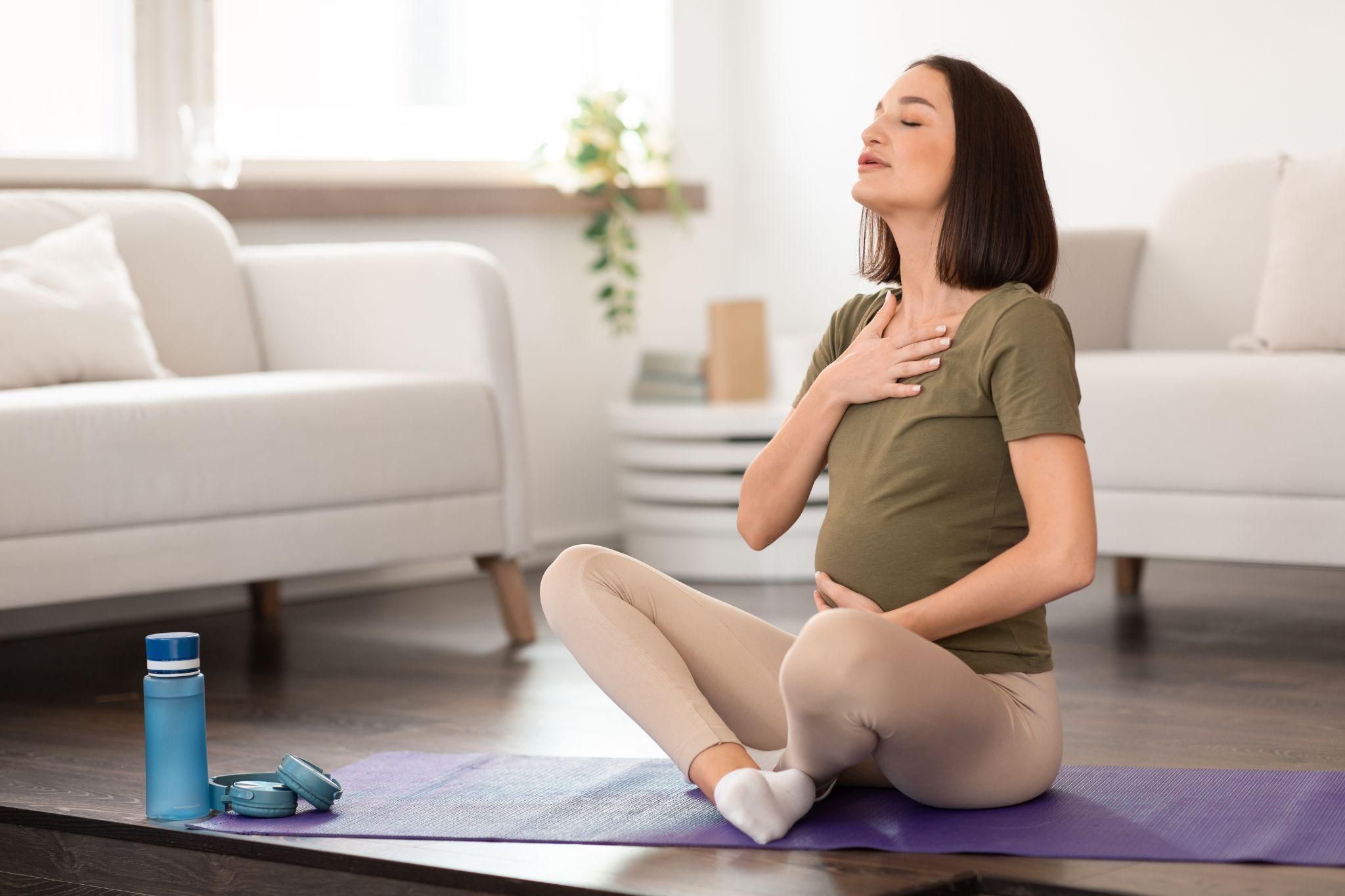 A pregnant woman doing breathing exercises in a prenatal yoga class.