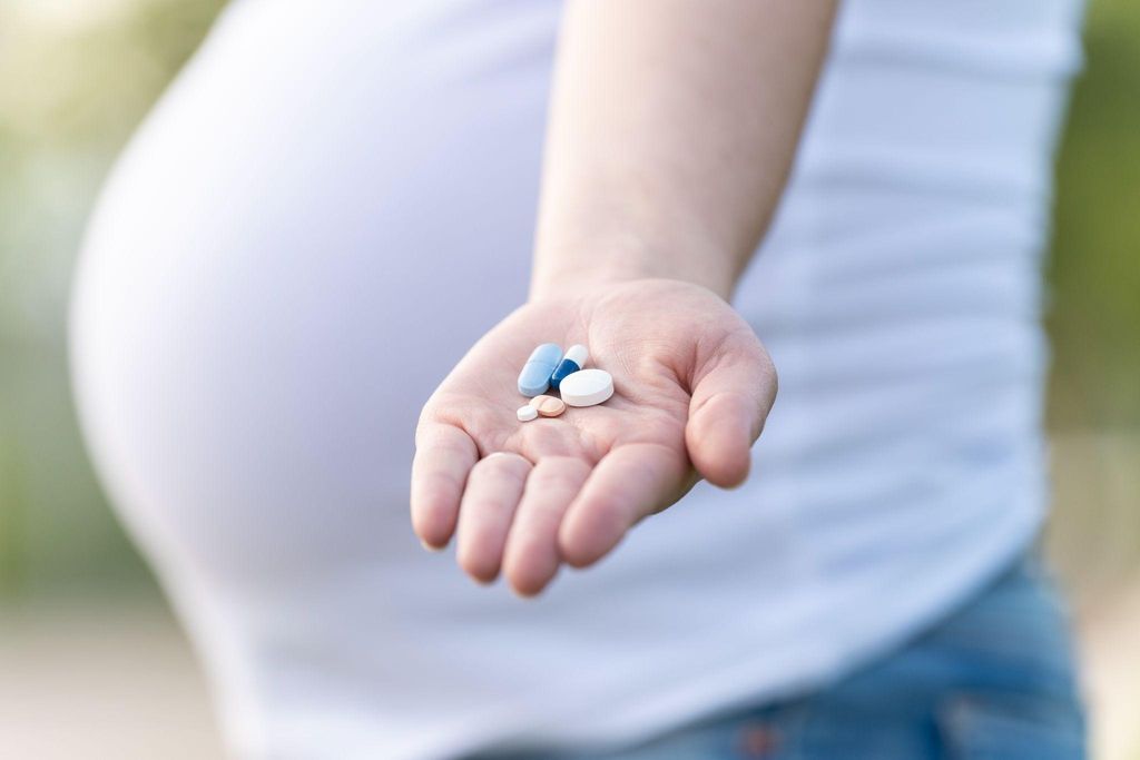 Pregnacare vitamins with a pregnant woman smiling in the background.