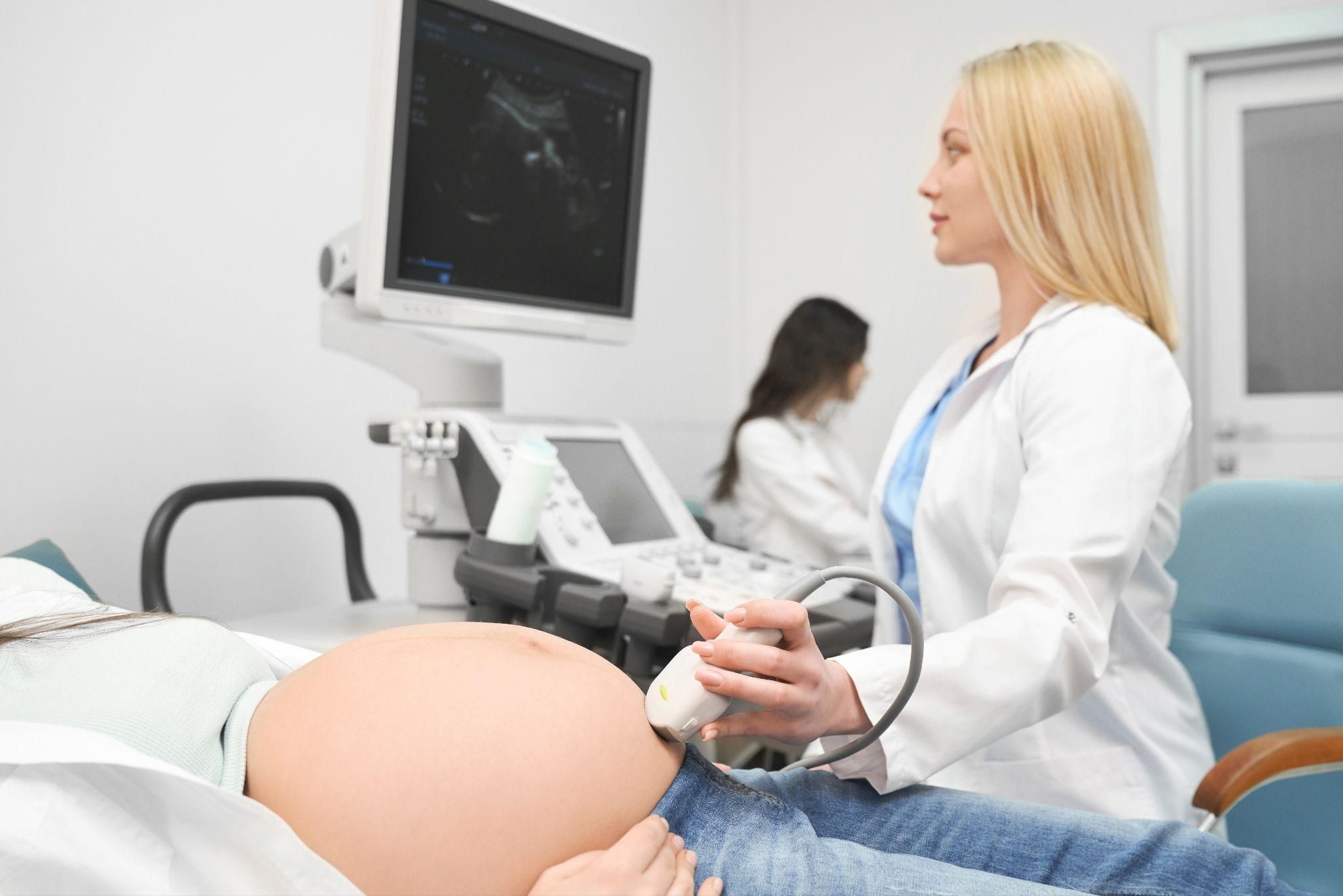 Pregnant woman having an ultrasound scan during an antenatal appointment.