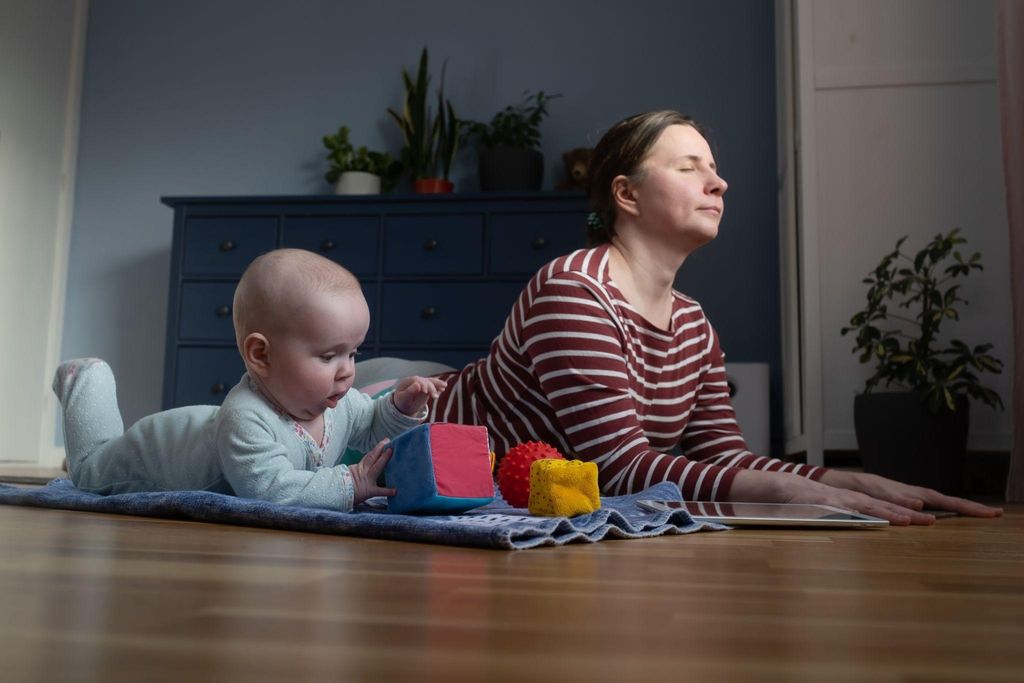 Postpartum woman practising yoga during pregnancy in a calm environment.