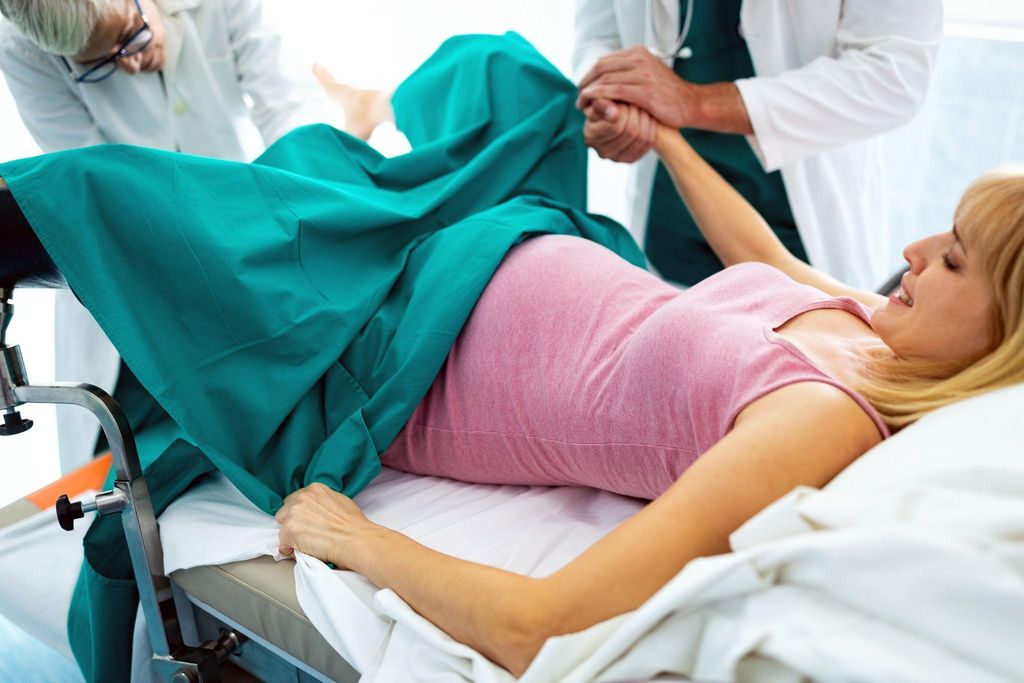 A healthcare provider performing a cervical check at an antenatal clinic.