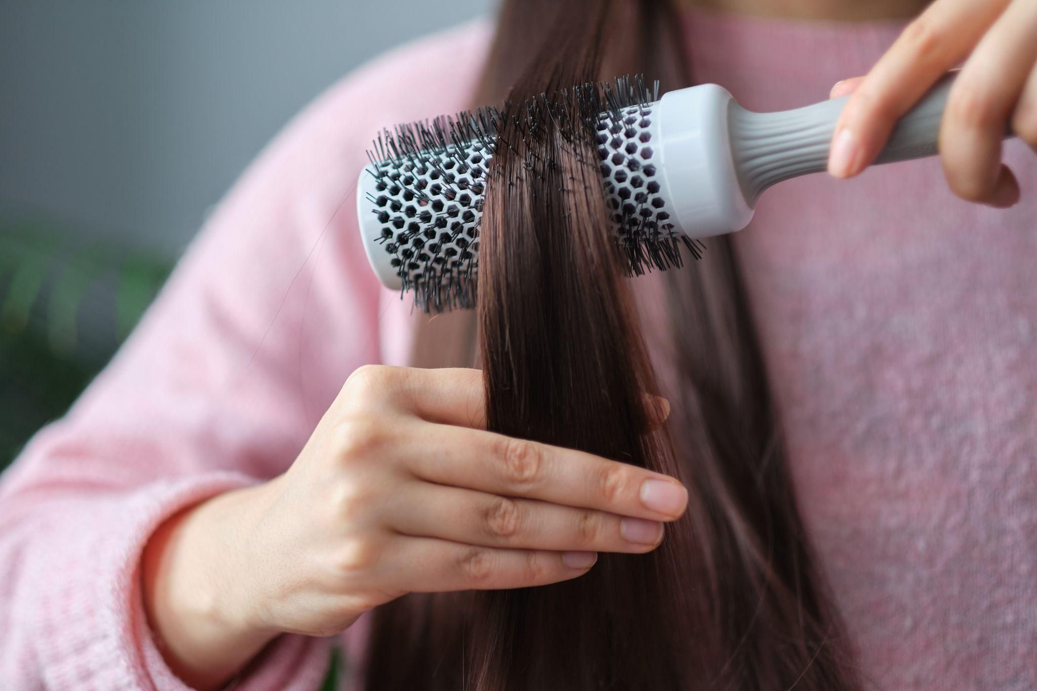 A relaxed mum practising hair care after pregnancy to maintain healthy, shiny locks.