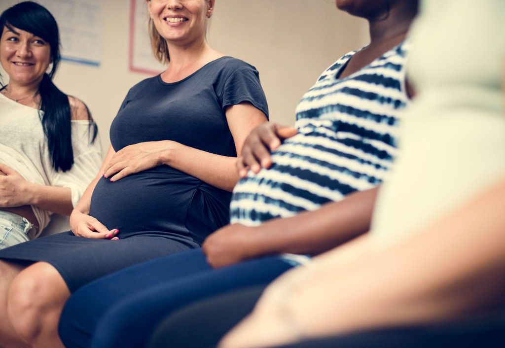 A healthy pregnant woman attends antenatal classes in a serene environment.