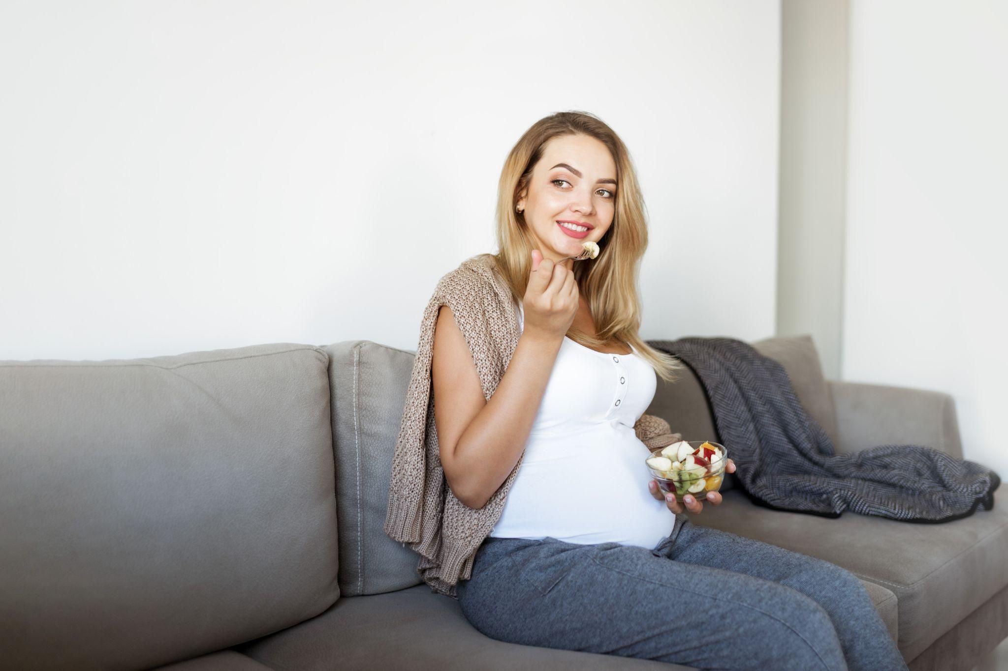 A pregnant woman managing pregnancy hunger with a nutritious snack.