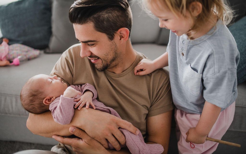 A dad bonding with his newborn while supporting his partner during the postpartum phase.