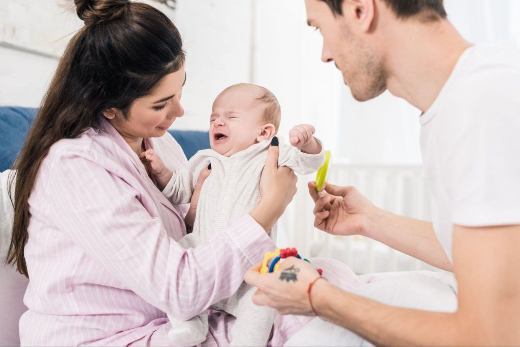 A couple bonding with their baby in a warm, family-friendly setting.