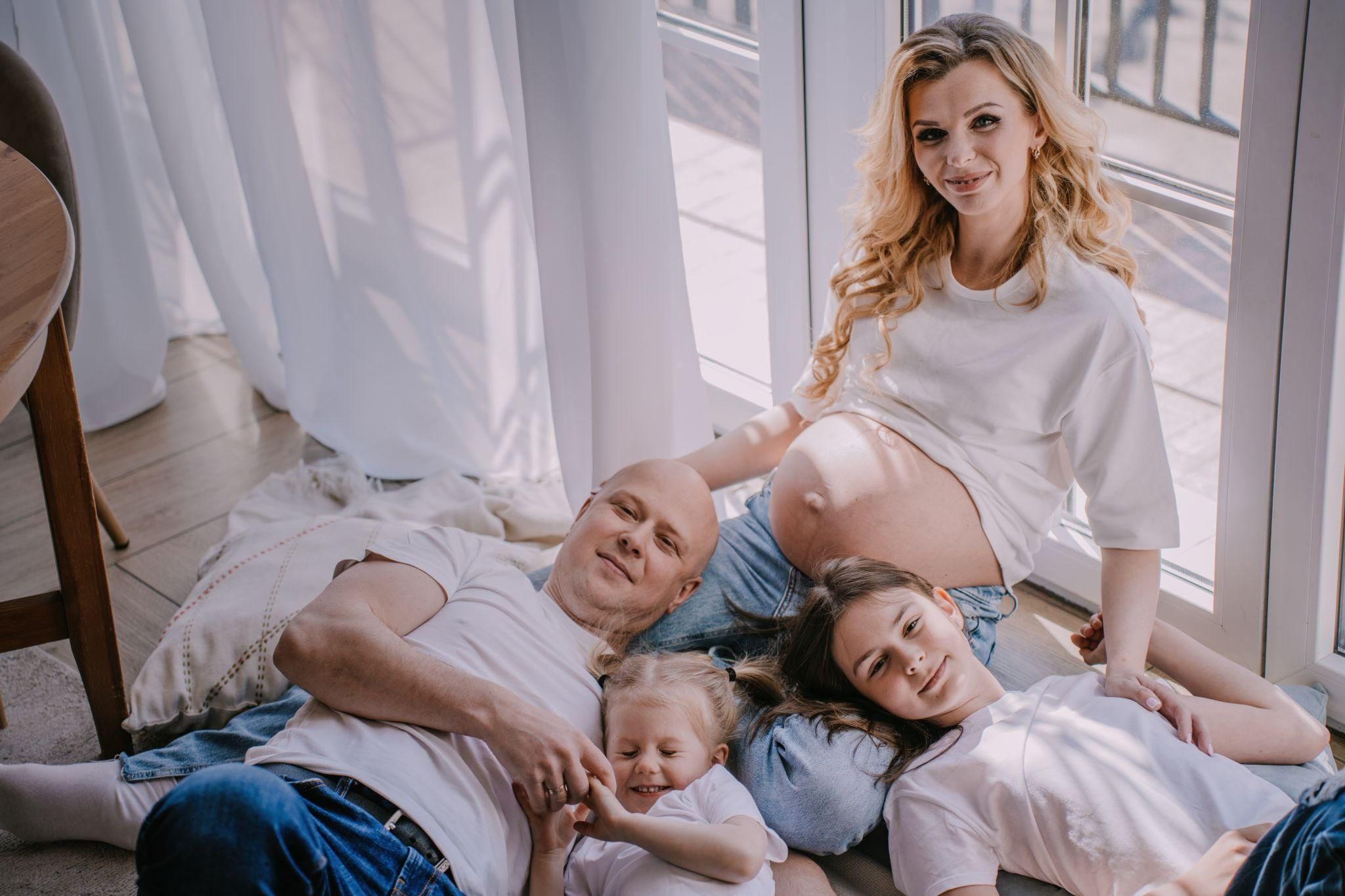 A family gathered together, listening to a mother explaining her pregnancy experience.