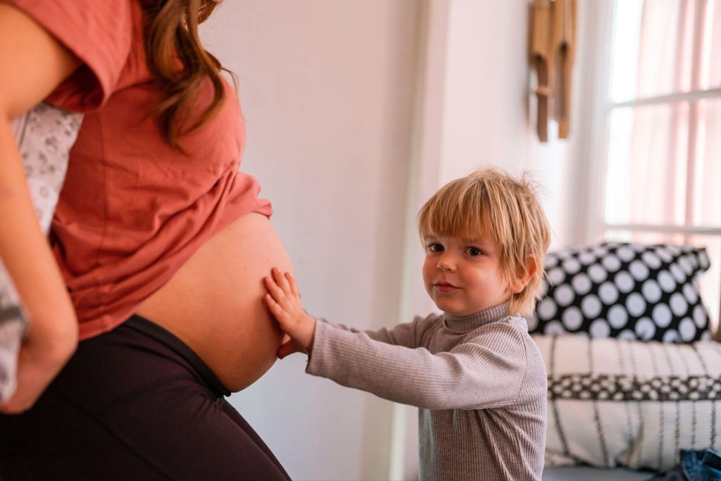 A pregnant woman tracking her baby’s antenatal movements with her son.