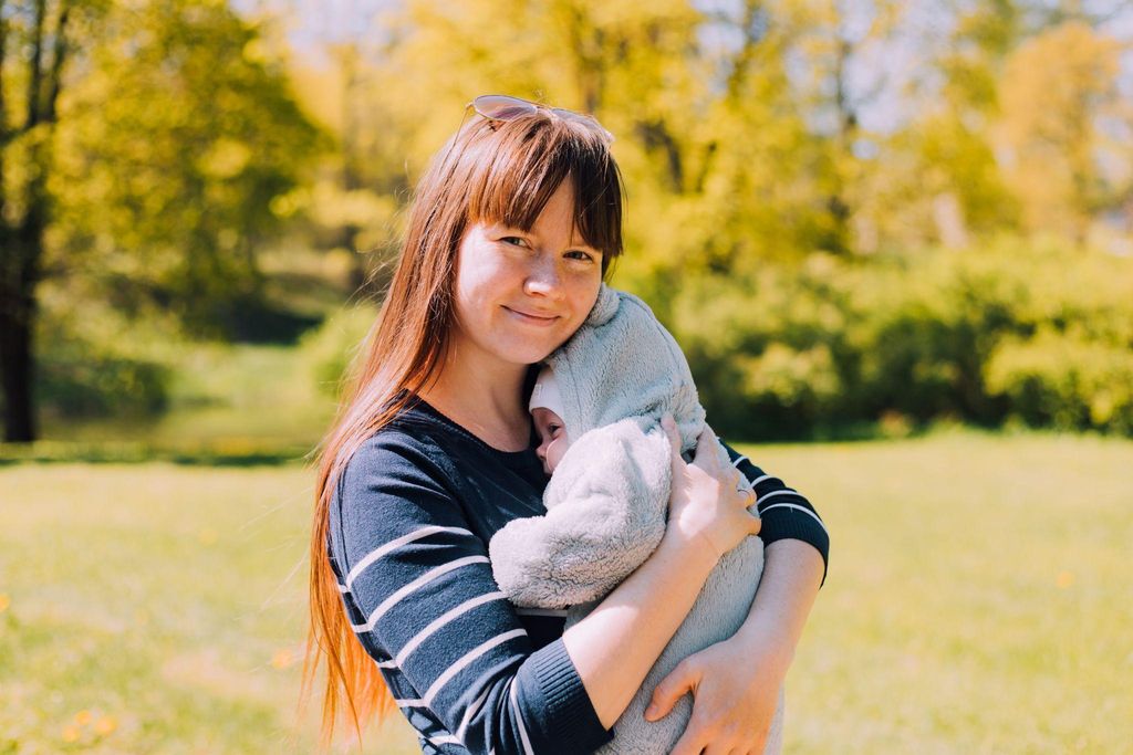 Mum soothes her new baby in the garder during her postnatal period.