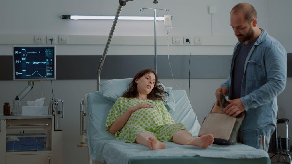 Expecting mother and birthing team practising relaxation techniques in a calm birthing room.