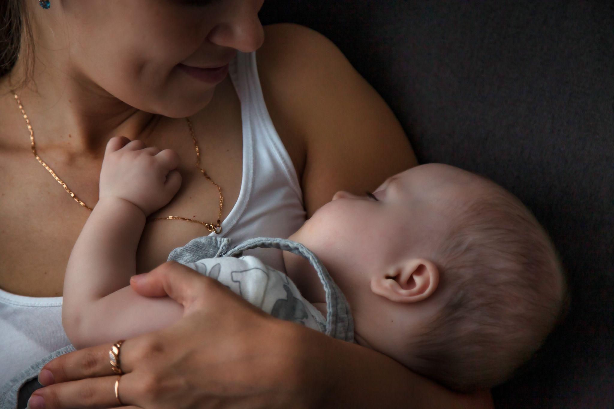 Mother comfortably breastfeeding her baby with the help of a breastfeeding pillow.