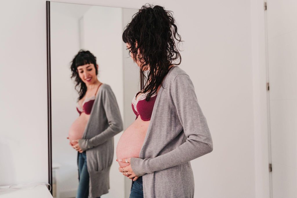 Pregnant woman holding her breasts due to breast leakage