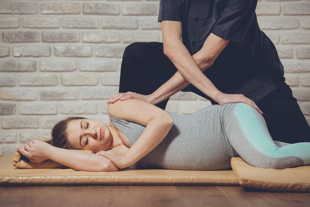 A pregnant woman enjoys a traditional Thai massage.