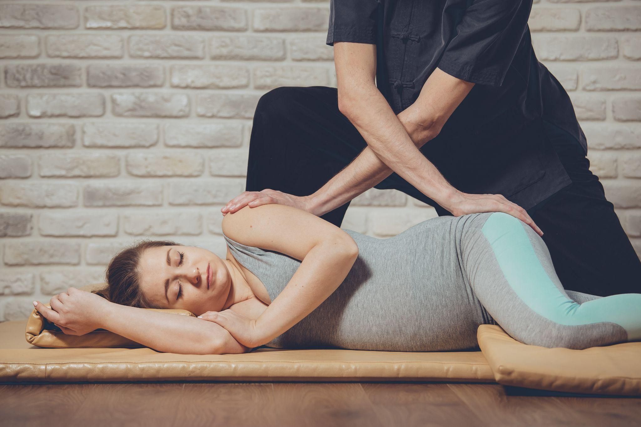 A pregnant woman enjoys a traditional Thai massage.