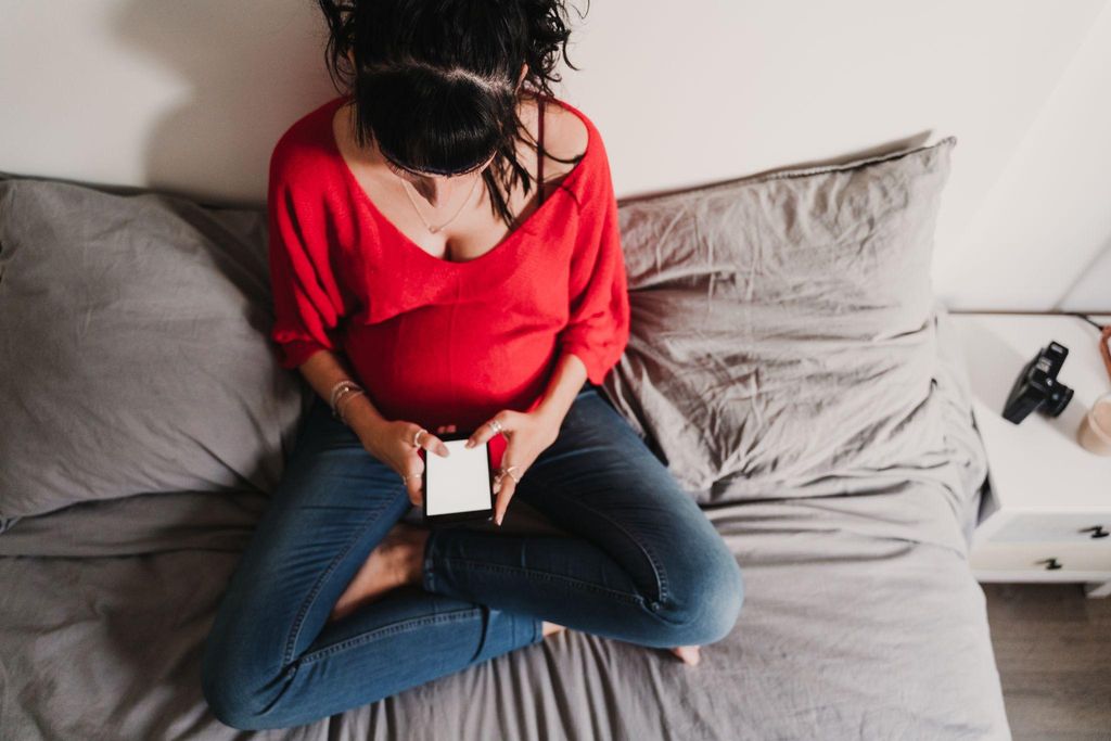 Pregnant woman calling midwife on her mobile phone.