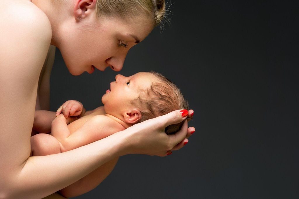 A 3-month-old infant reaching for a toy, representing the transition from newborn to infant.