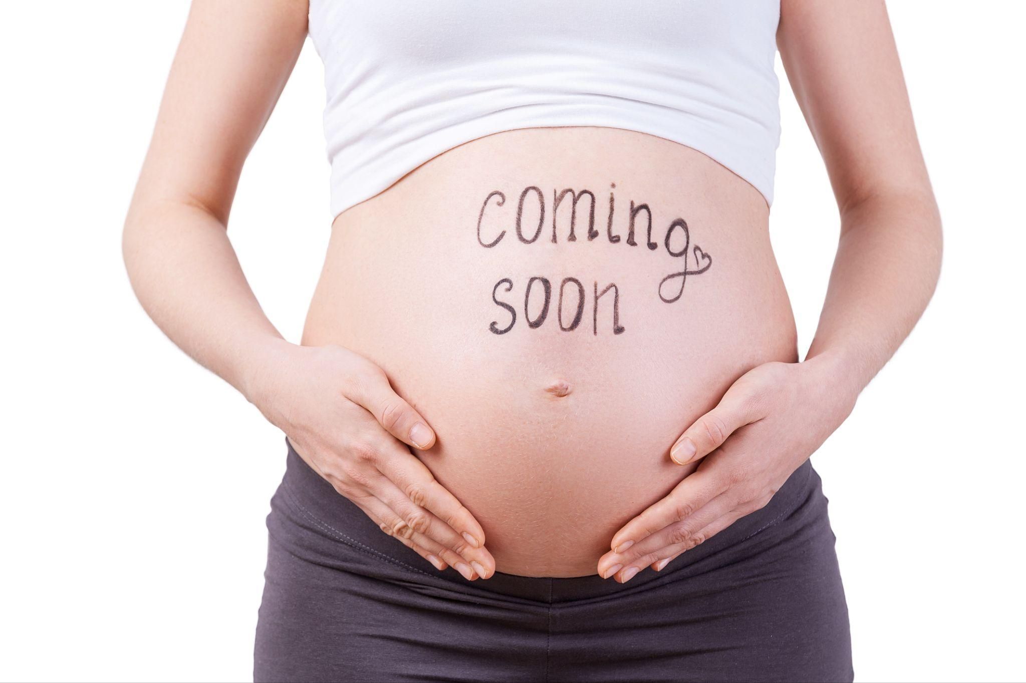 A pregnant woman attending an antenatal yoga class with a group of expectant mothers.