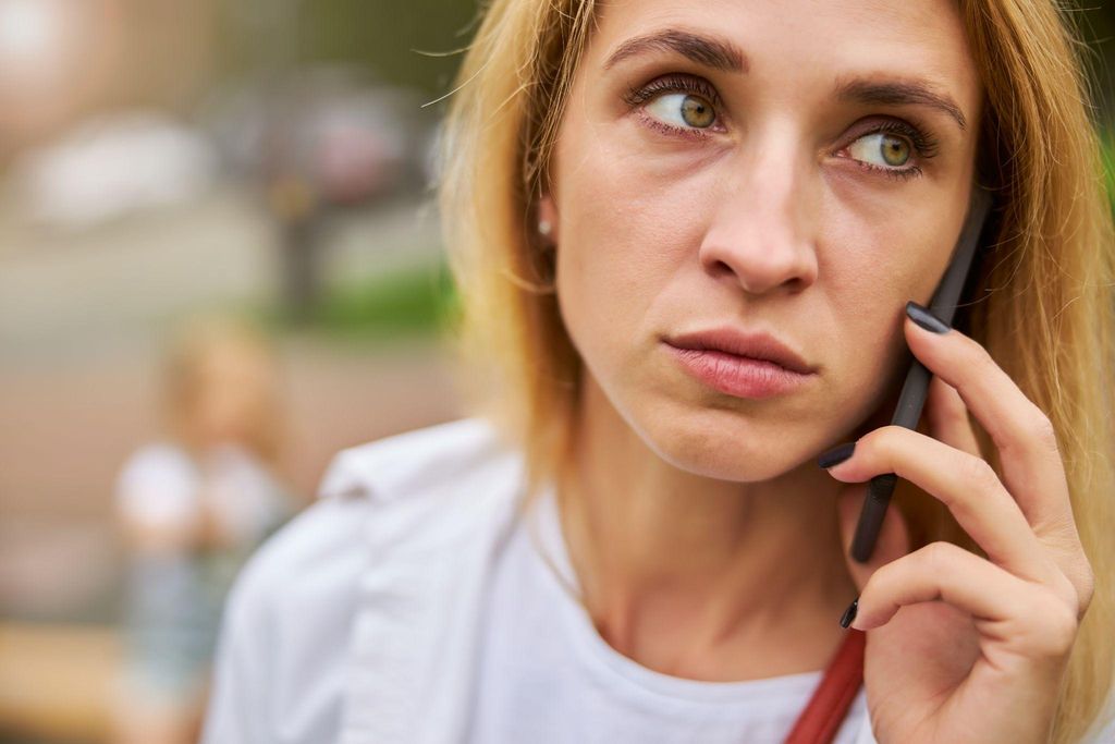 Worried pregnant woman on mobile phone.