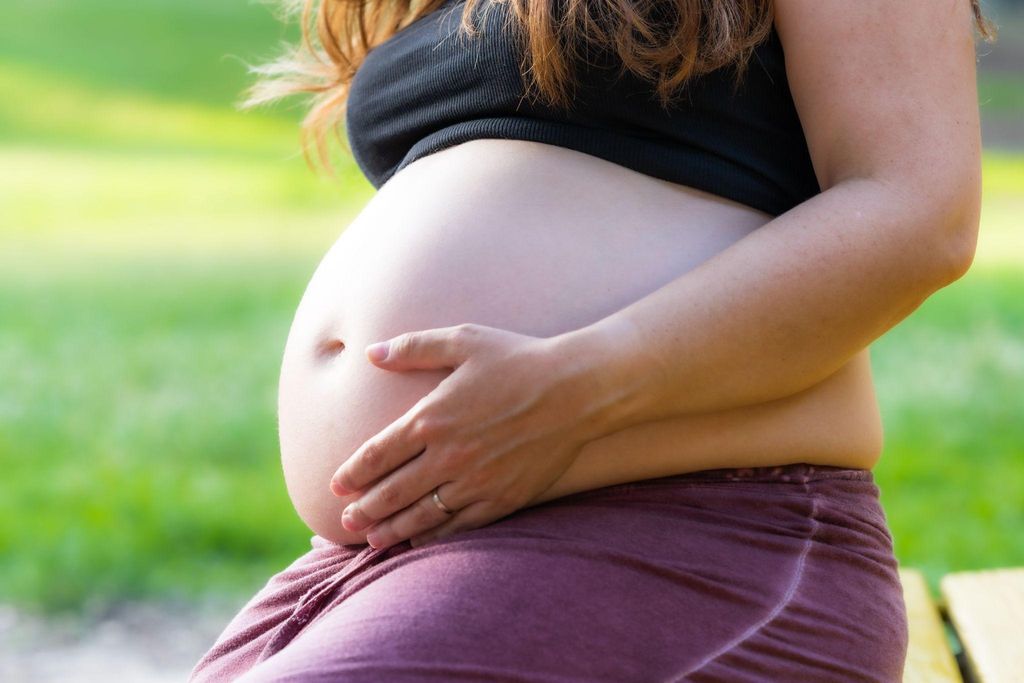 A pregnant woman at 38 weeks practicing prenatal yoga, breathing deeply and focusing on relaxation.