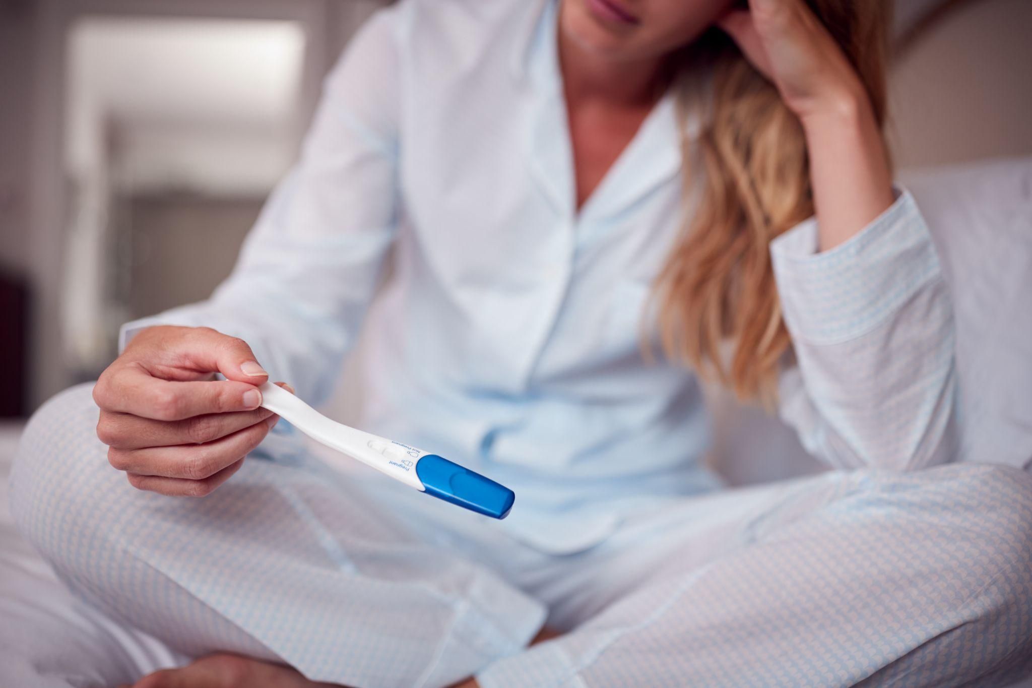 A pregnancy test alongside a marked calendar and antenatal vitamins, representing next steps after a missed period.