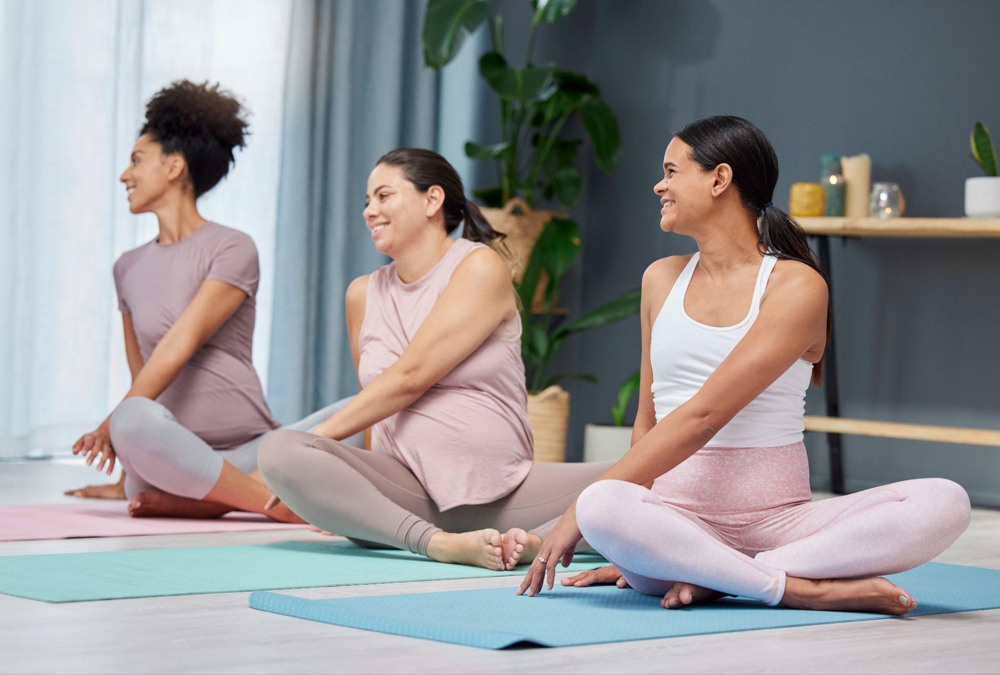 A pregnant woman practising squats for antenatal birth preparation in a fitness class.