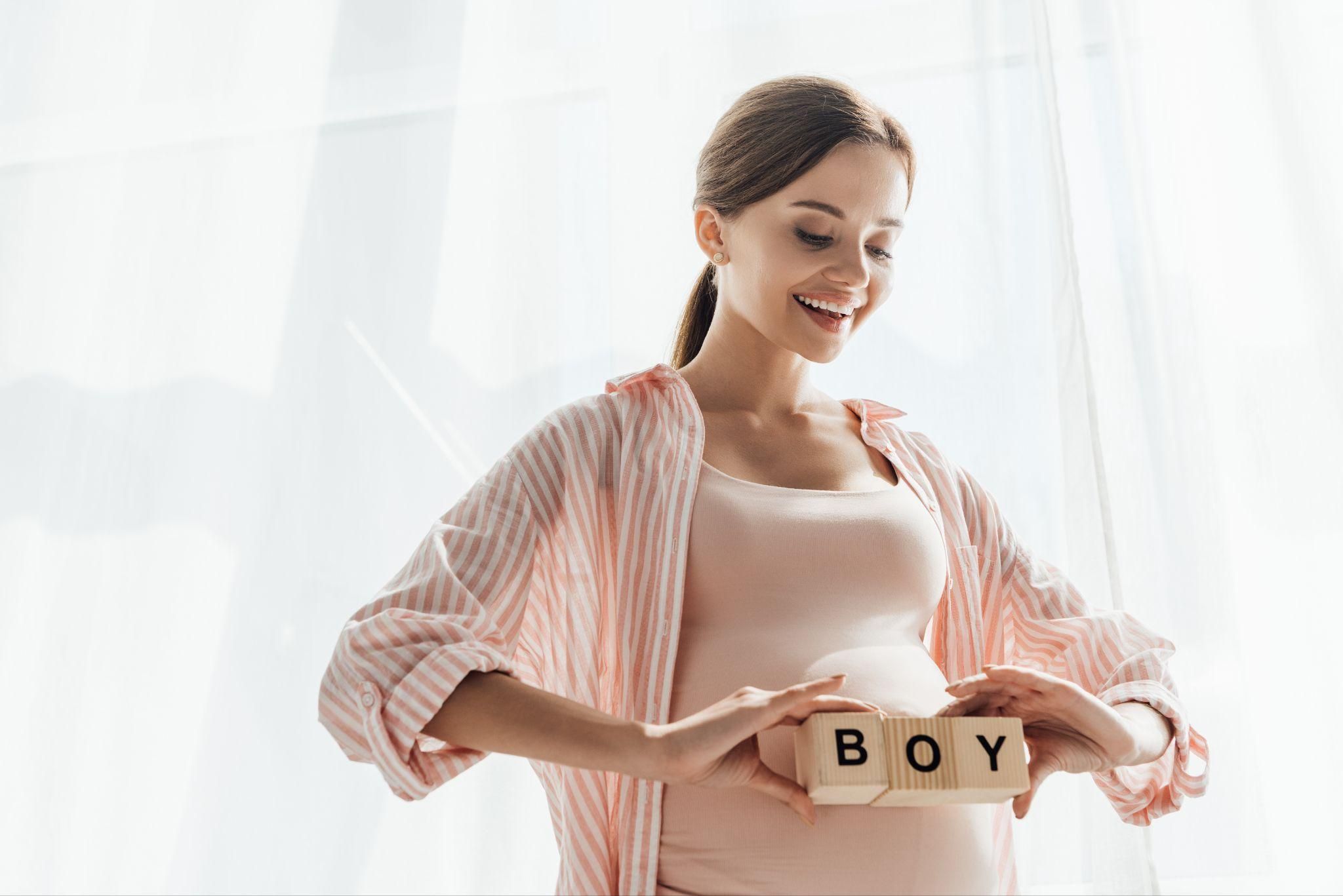 Pregnant woman looking forward to the upcoming gender reveal of her baby.