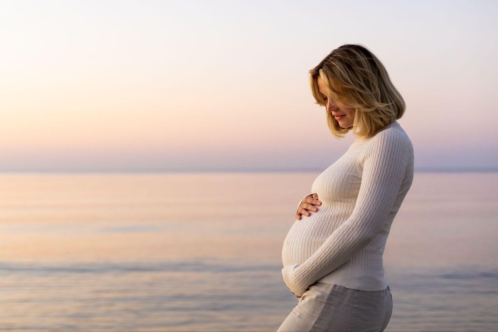 A peaceful image of a pregnant woman reflecting on early pregnancy symptoms.