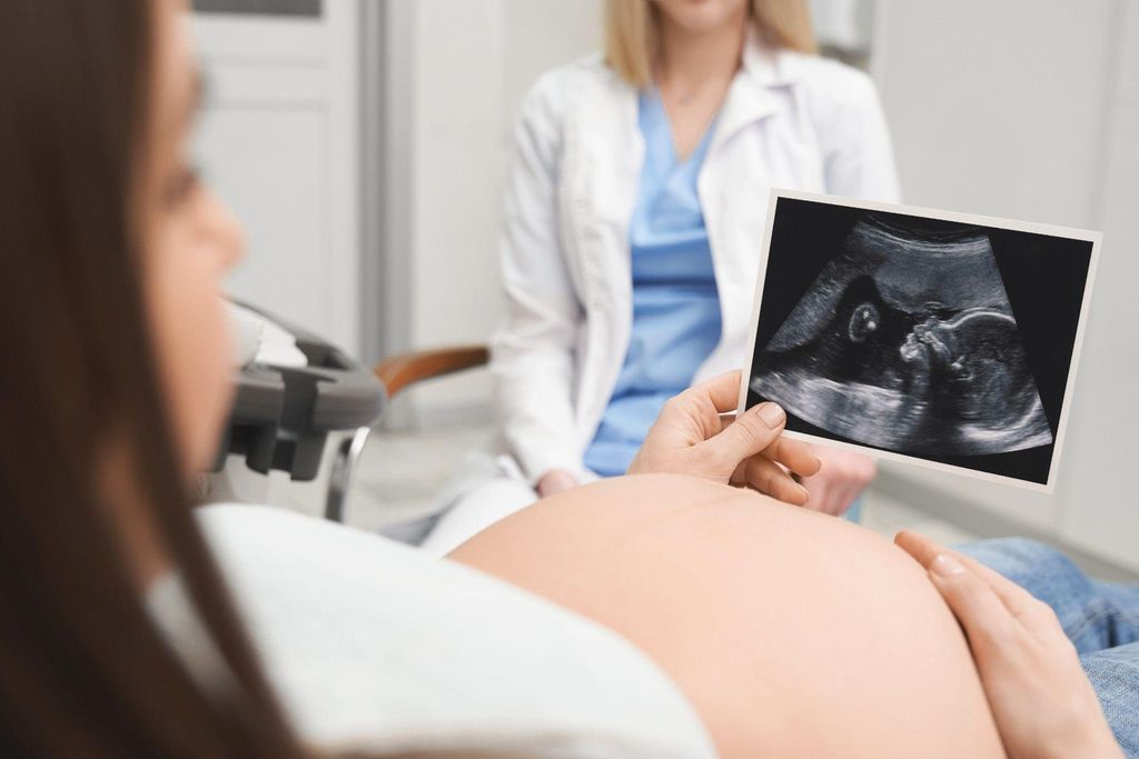 Pregnant woman having an ultrasound scan during an antenatal appointment.