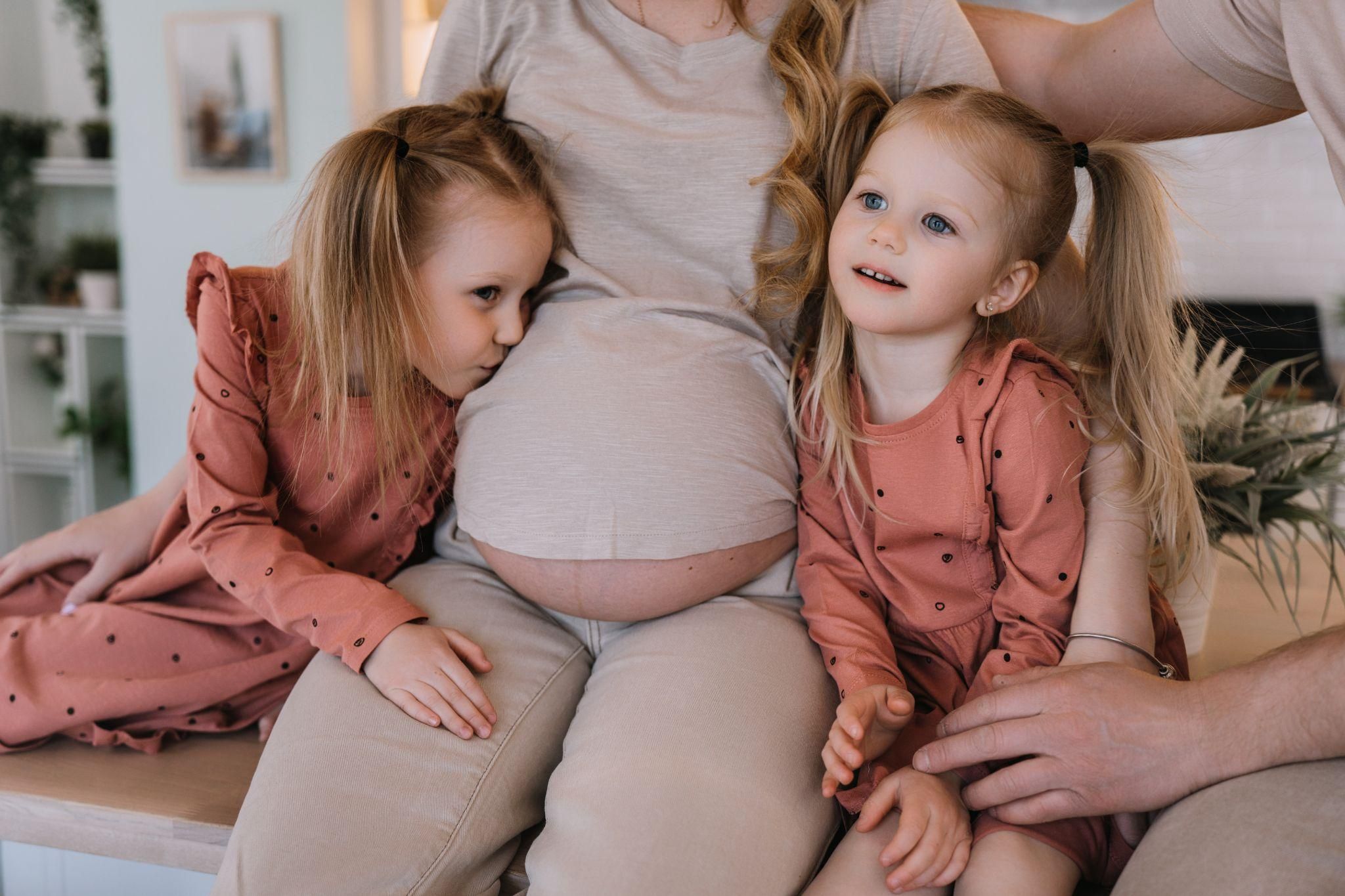 Expectant mother receiving antenatal support from loved ones and medical professionals.