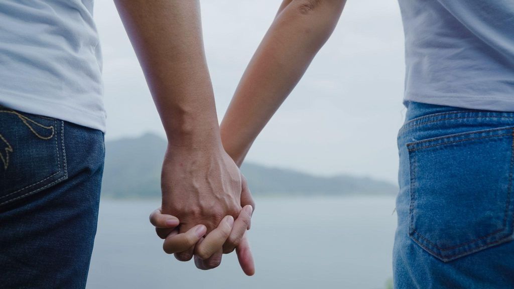 A grieving couple holding hands, symbolising support after miscarriage.