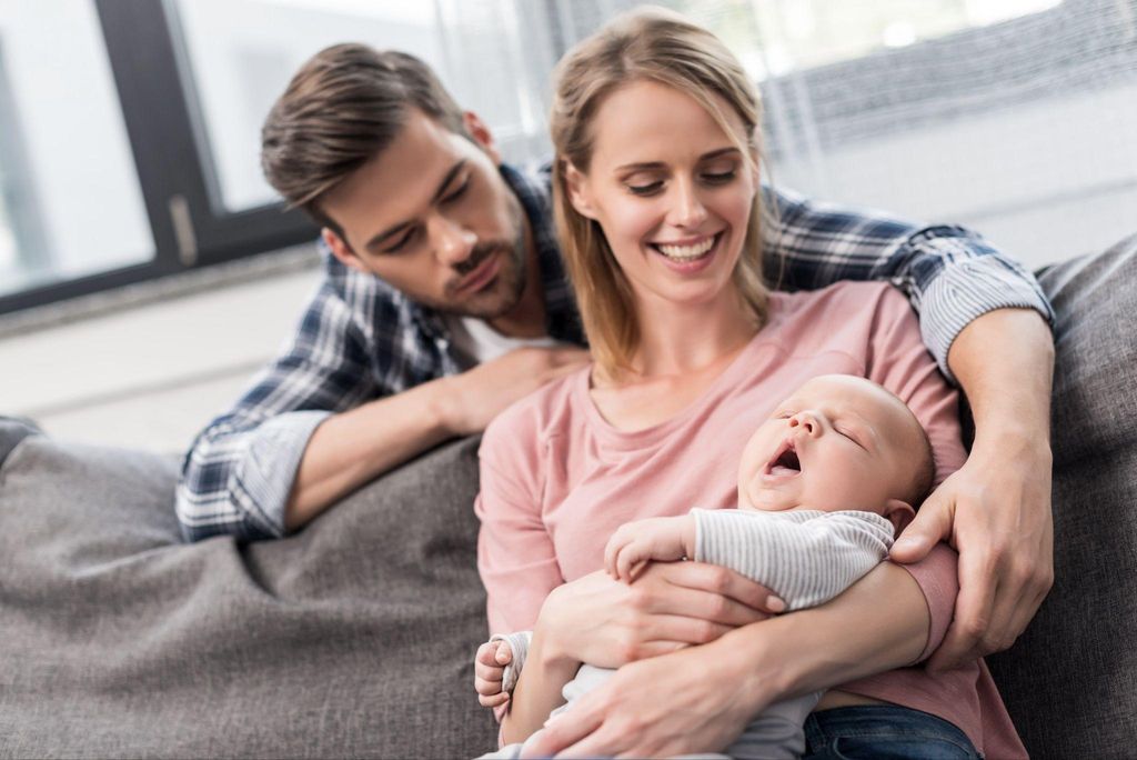 New parents sharing a tender moment with their baby.