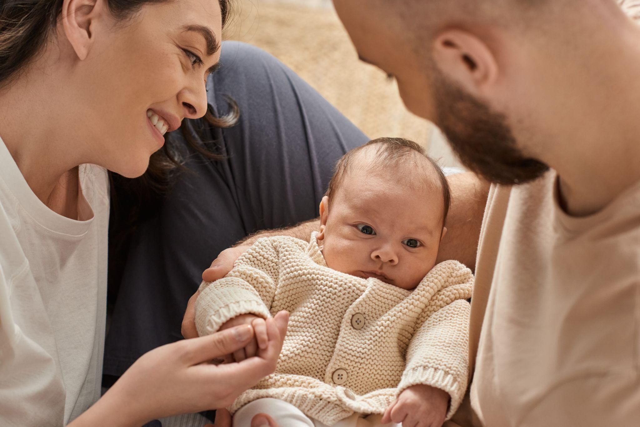 Baby with joyful new parents: