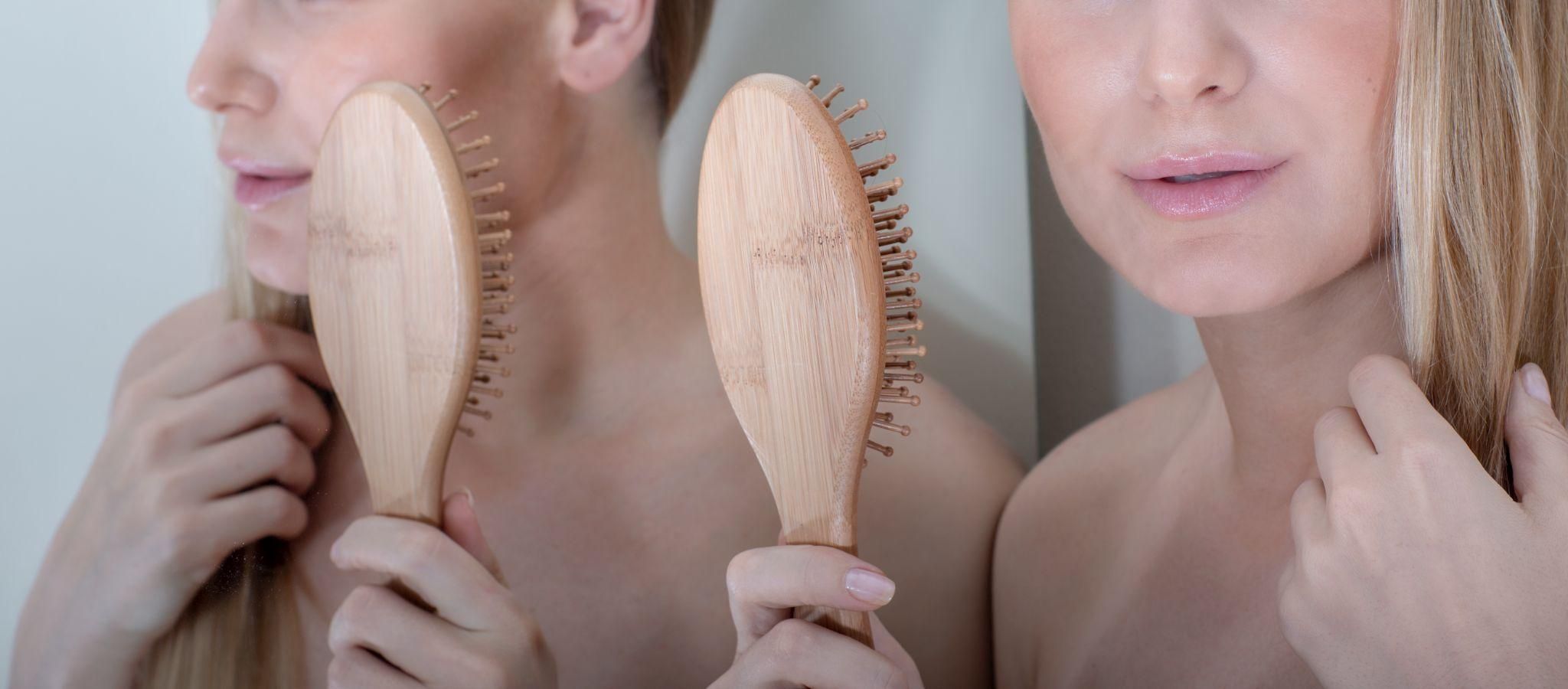 A relaxed mother focusing on her hair care routine post-pregnancy.