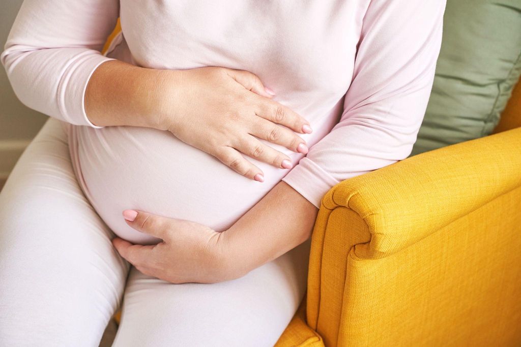 Pregnant woman feeling her belly to check baby’s position.